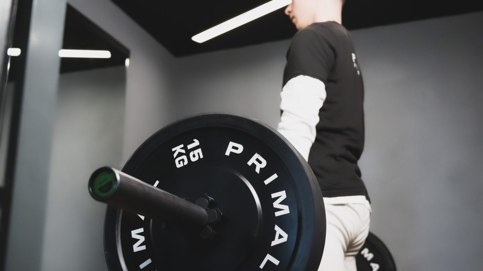 A member training with a Primal barbell at Prime Performance